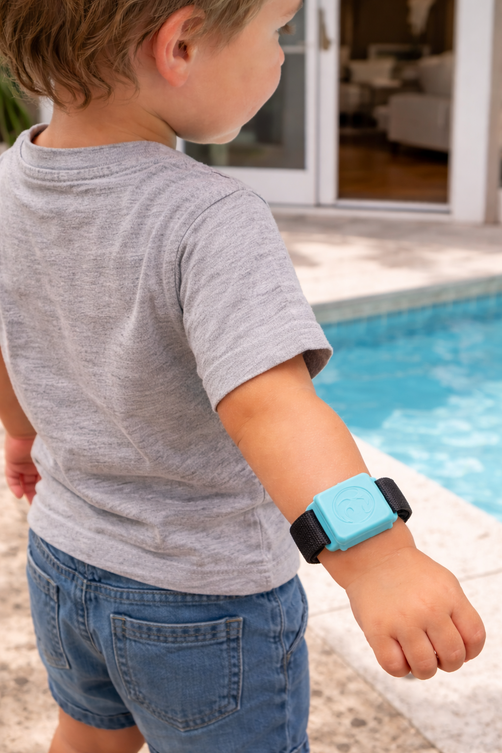 Child wearing Water Watch device near swimming pool